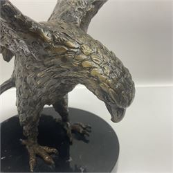 Bronze eagle, modelled in a standing position with wings spread, raised on a black veined marble circular plinth base, H29cm