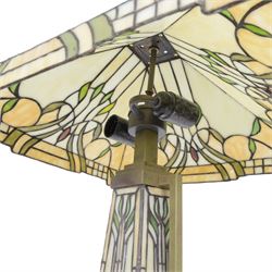 Tiffany style table lamp, the tapering stem and stepped pyramid shade, with naturalistic green foliate decoration on a cream ground, including shade H67cm