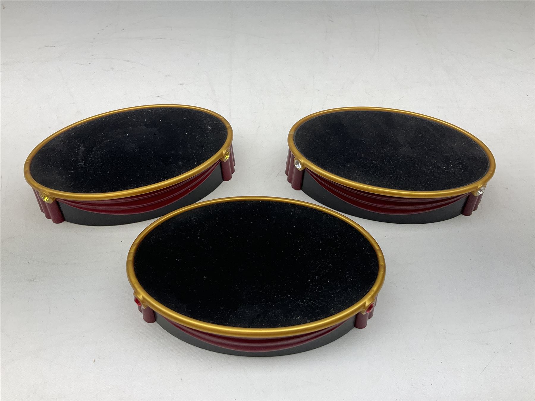 Swarovski Crystal Masquerade trilogy; 1999 Masquerade Pierrot, 2000 Columbine, 2001 Harlequin all with accompanying plaque, stand and original box, together with a glass display case with mirrored back and sides 