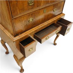 George II figured walnut chest-on-stand, the moulded cavetto top over two short and three long graduating cross-banded drawers, each fitted with pressed brass handle plates, the base fitted with three further drawers over a shaped apron, raised on cabriole supports with pad feet