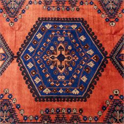 Central Persian Veis hand-knotted carpet, madder red field, decorated with a repeating arrangement of large octagonal and diamond medallions filled with stylized cross and geometric motifs and angular tribal devices within a series of geometric borders in tones of madder red, indigo blue, ivory, and soft green, with cotton fringe ends 