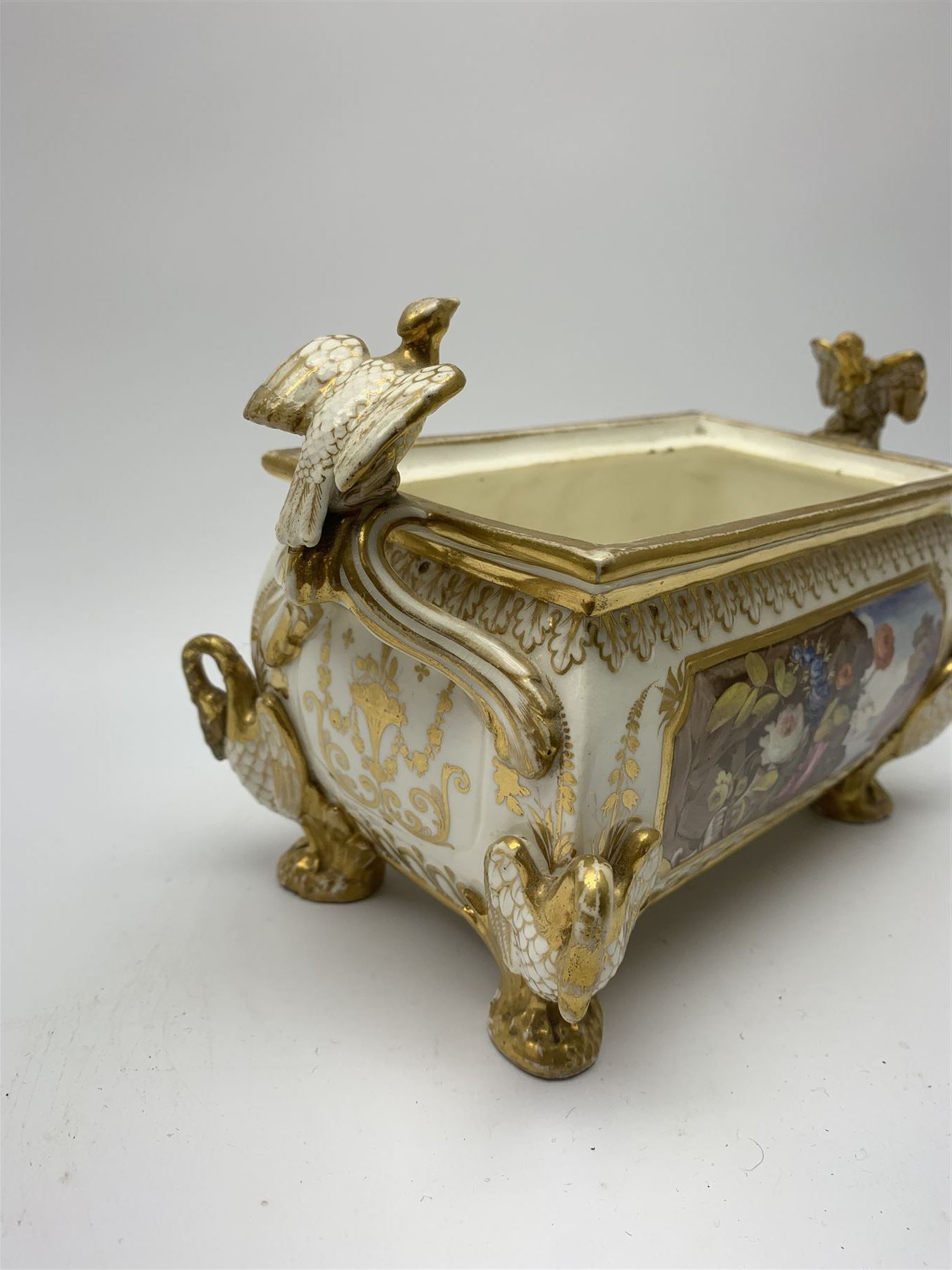 19th century Coalport bough pot, circa 1820, of bombe form, the body with twin handles surmounted by two birds and raised upon four feet modelled as swans, hand painted with two panels depicting an urn of flowers set against a mountainous landscape, the whole heightened in gilt throughout, H13cm L21cm