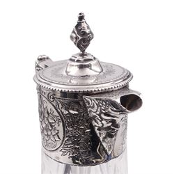 Modern silver mounted cut glass claret jug, in the Victorian style, the tapering cylindrical body with foliate embossed collar, Bacchus mask spout, conforming mask and foliate detail to angular scroll end handle, and hinged cover, hallmarked London 1994, makers mark W W, H27.5cm