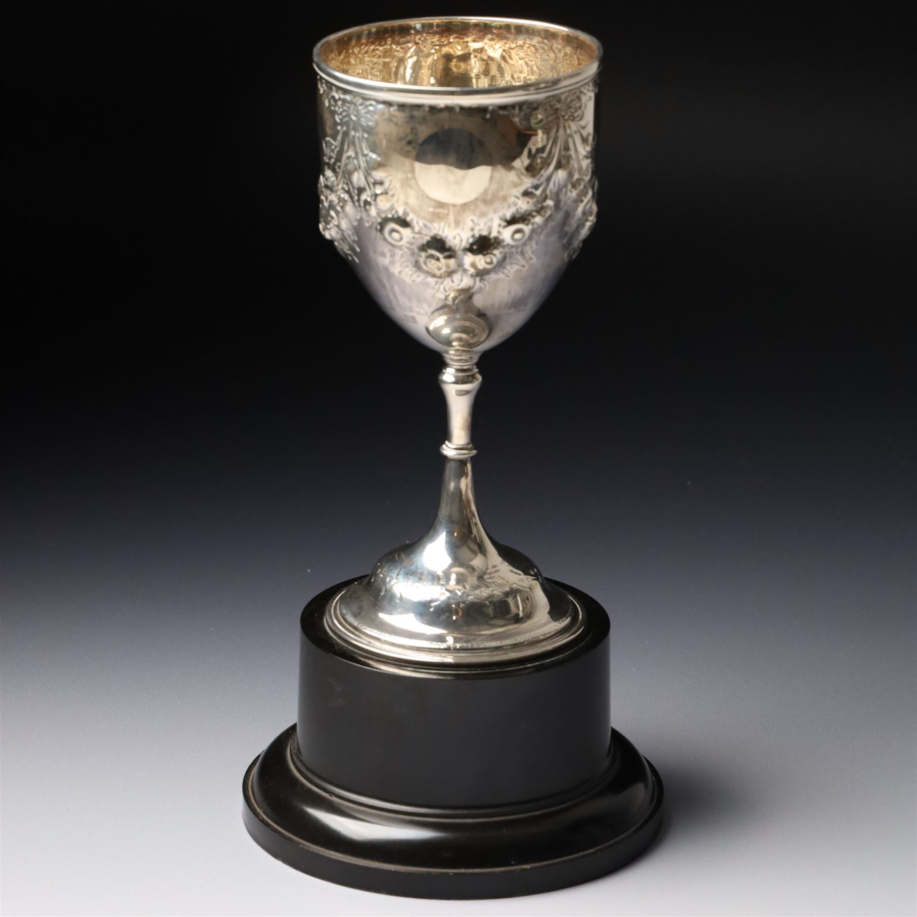 Victorian silver cup with embossed decoration on a plastic base, height of cup 16cm Birmingham 1868 and a small silver challenge cup 'Whitby Show 1950'