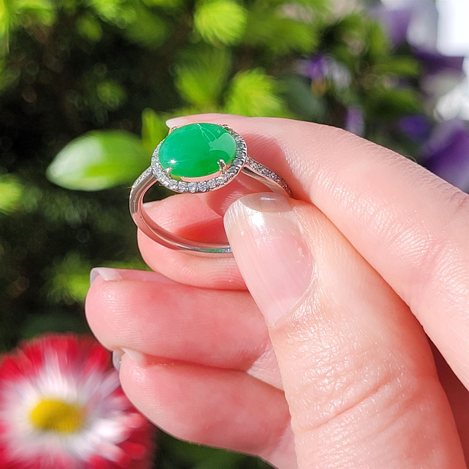 Platinum jadeite and diamond cluster ring, single oval cabochon cut jadeite of 2.20 carat, surrounded by round brilliant cut diamonds and diamond set shoulders, stamped Plat