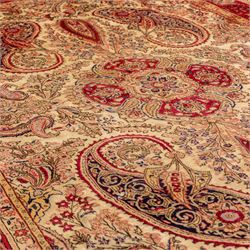 West Central Persian Sarouk hand-knotted carpet, ivory field with central ornate medallion and scrolling vines and palmettes, surrounded by large stylized boteh motifs and flowering foliage, enclosed by a madder-red border of palmettes and floral vine ornament between multiple guard stripes, cotton fringe ends 