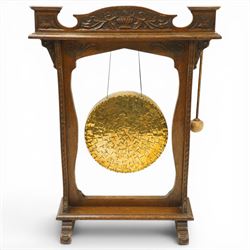 Late Victorian Arts & Crafts carved oak framed floor standing dinner gong, the cresting ra...