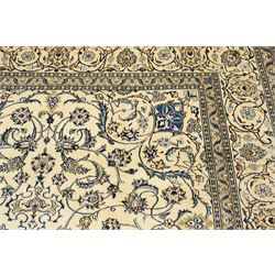 Central Persian Nain hand-knotted carpet, ivory field with central radiating medallion, issuing an all-over design of scrolling vines, palmettes, and delicate floral sprays with conforming spandrels, enclosed by a foliate border, framed by multiple guard stripes, with cotton fringe ends 