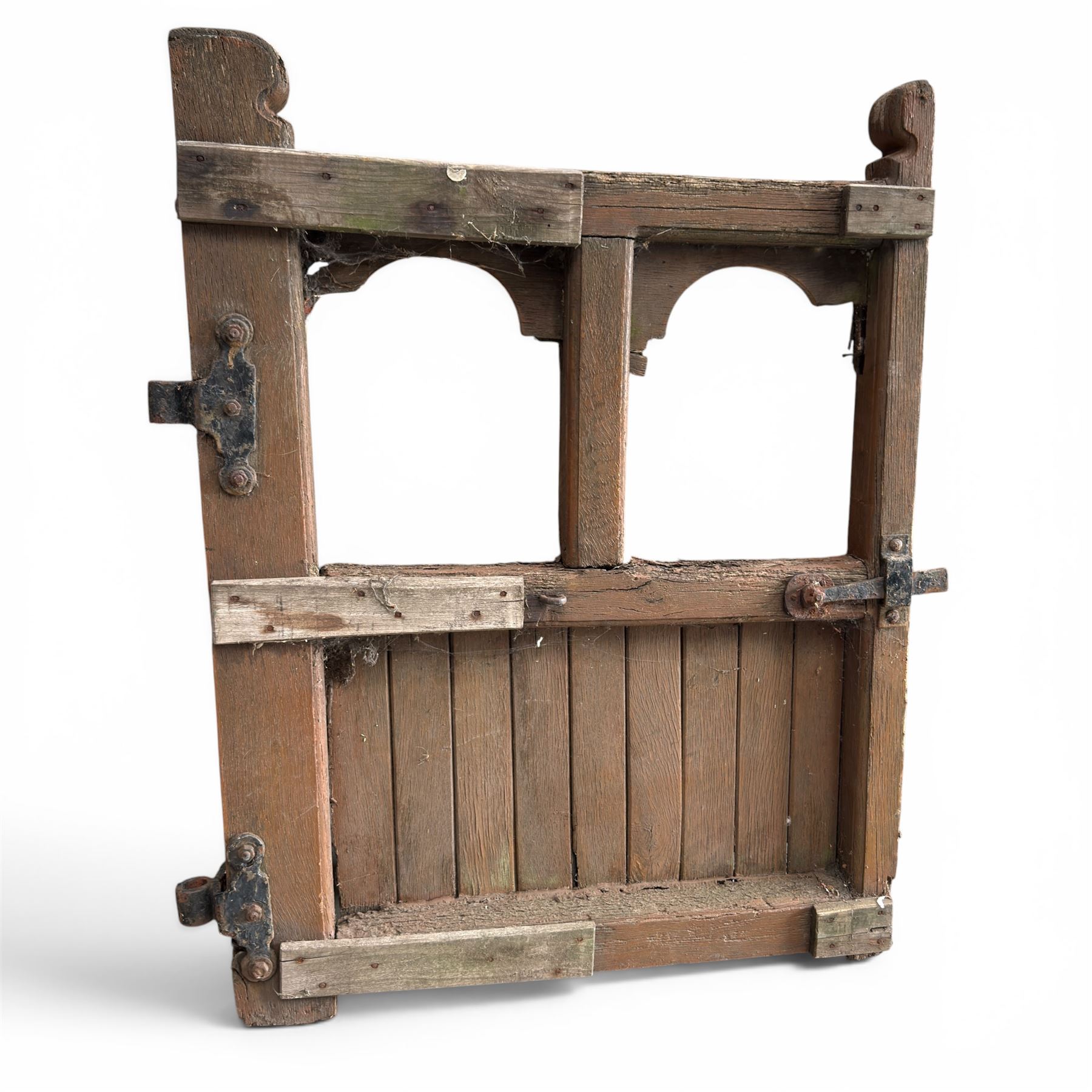 Pair of 19th century weathered wooden ecclesiastical church gates, the cresting rail over four pierced arches with slatted lower section, fitted with heavy cast iron hinges, latch and fittings