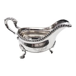 George III silver sauce boat, of typical form with gadrooned rim, and acanthus capped scroll handle, upon three shell mounted shell pad feet, with engraved crest to body, hallmarked George Methuen, London 1760, including handle H13cm, approximate total weight 14.4 ozt (450.6 grams)