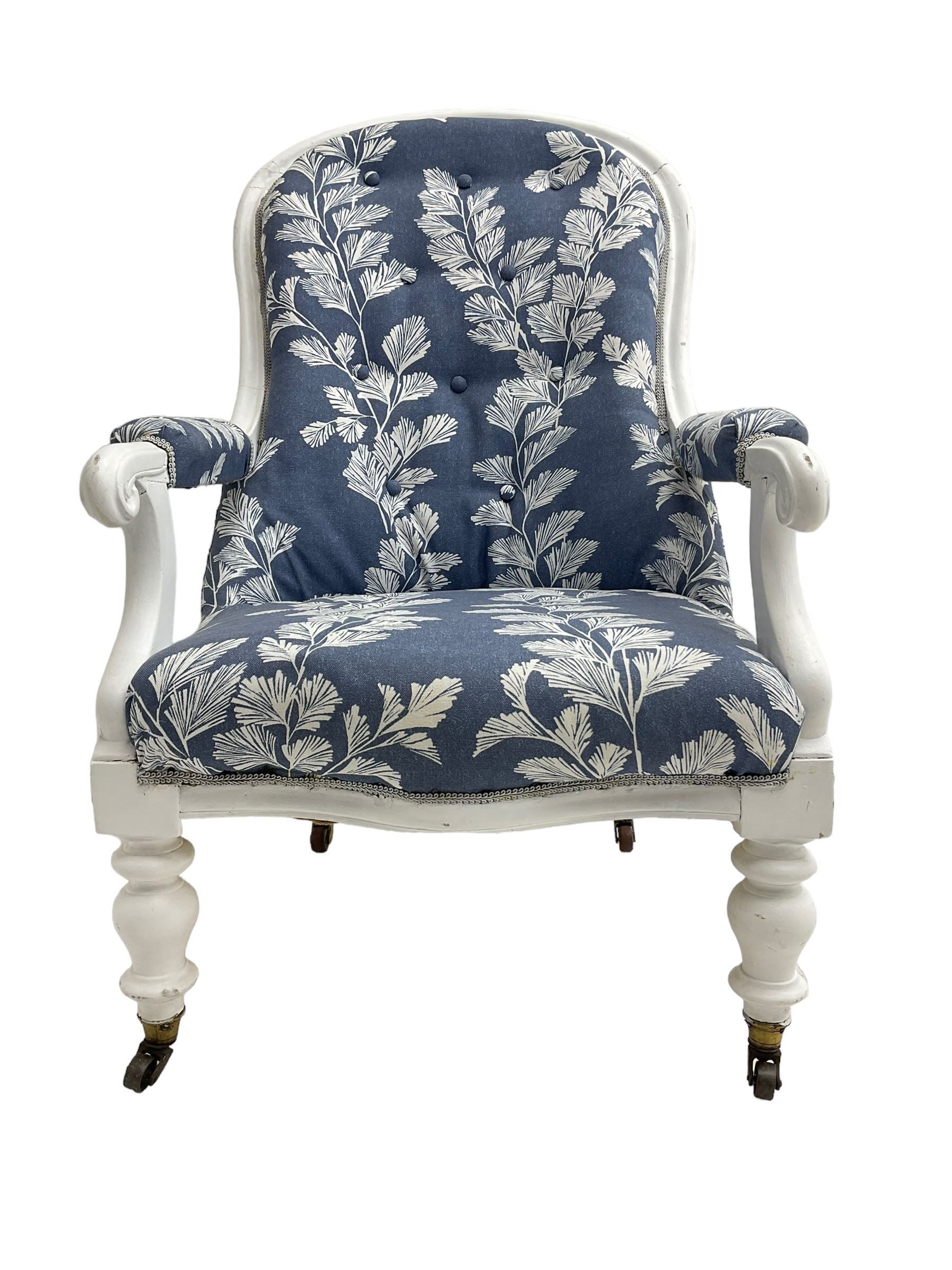 Victorian white painted open armchair, upholstered in blue fabric decorated with trailing leaf pattern, scrolled arm terminals on turned front supports with castors