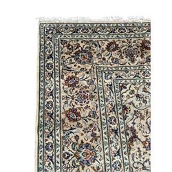 Persian Kashan ivory ground carpet, the field decorated with interlacing foliate branches and stylised plant motifs, scrolling border decorated with repeating palmettes, within floral pattern guard bands