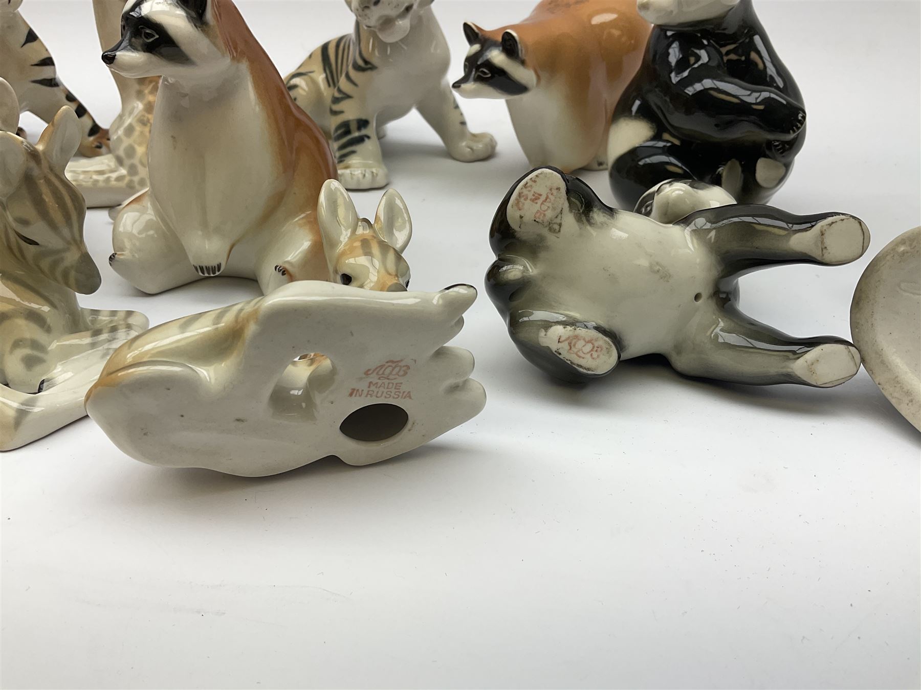 A collection of Russian animal figures, largely comprising Lomonosov examples, to include examples modelled as tigers, zebra, pandas, brown bears, giraffe, and racoons. 