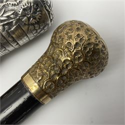 Malacca walking cane mounted with continental silver cap, embossed with landscape scene, together with a ebonised wooden walking cane, mounted with an 18ct gold plated cap, embossed with scrolls, tallest H89cm