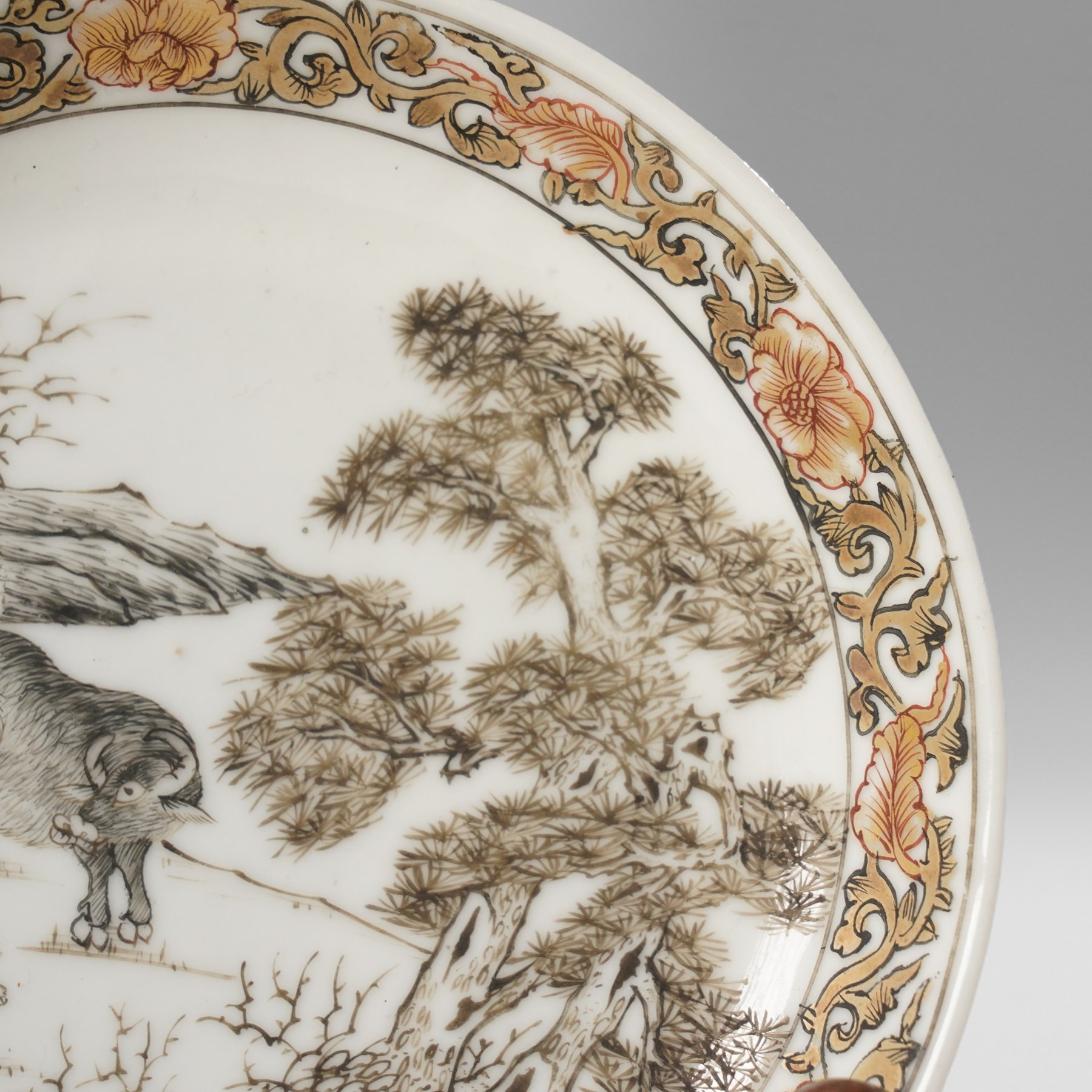 Chinese Yongzheng period saucer, finely painted in grisaille with buffalo within a rocky landscape, the inner rim with iron red and gilt foliate band, D11.5cm