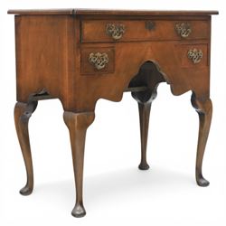Early 20th century walnut lowboy in Queen Anne style, rectangular crossbanded top over single long drawer and two short drawers with shaped apron, fitted with brass drop handles and backplates, raised on cabriole supports terminating in pad feet