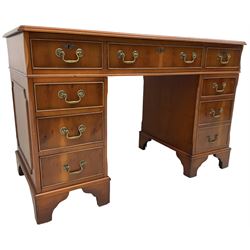 Georgian design yew wood twin pedestal desk, rectangular top with green leather inset writing surface, fitted with nine cock-beaded drawers, on bracket feet