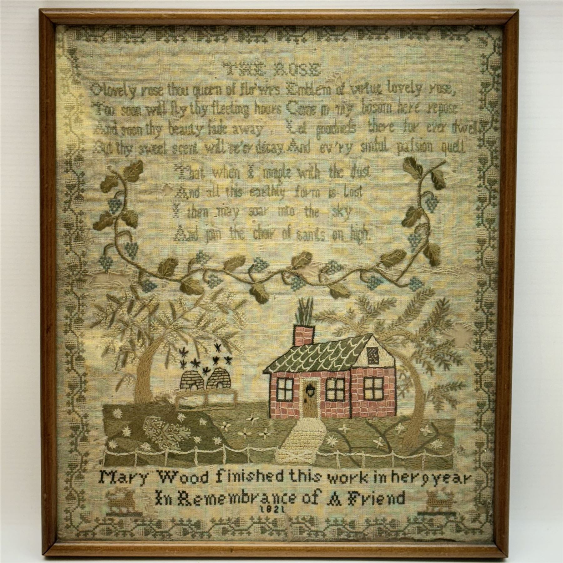 George IV sampler by Mary Wood aged nine, depicting verse titled The Rose, 'O lovely rose thou queen of flo'wrs Emblem of virtue lovely rose, Too soon will fly thy fleeting hours Come in my bosom here repose And soon thy beauty fad away Let goodnfs there for ever dwell But they sweet scent will ne'er decay And ev'ry sinful palsion quell That when I mingle with the dust And all this earthly form is lost I then may soar into the sky And join the choir of saints of high', above a fruiting vine and scene with cottage, beehives and trees, detailed 'Mary Wood finished this work in her 9 year in remembrance of a friend', within a vine border, within an oak frame under glass, sampler 31cm x 26.5cm, 