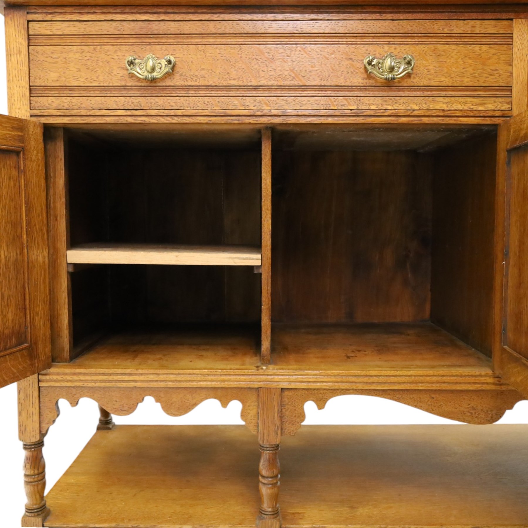 Maple & Co. - Arts & Crafts oak dresser with stained glass cupboard, raised section with pierced pediment above a mirrored back, with a stained glass fronted cupboard with fixed shelf, single long drawer, above a pair of fielded panels, with open recess above a short drawer, raised above a full length undertier with turned supports