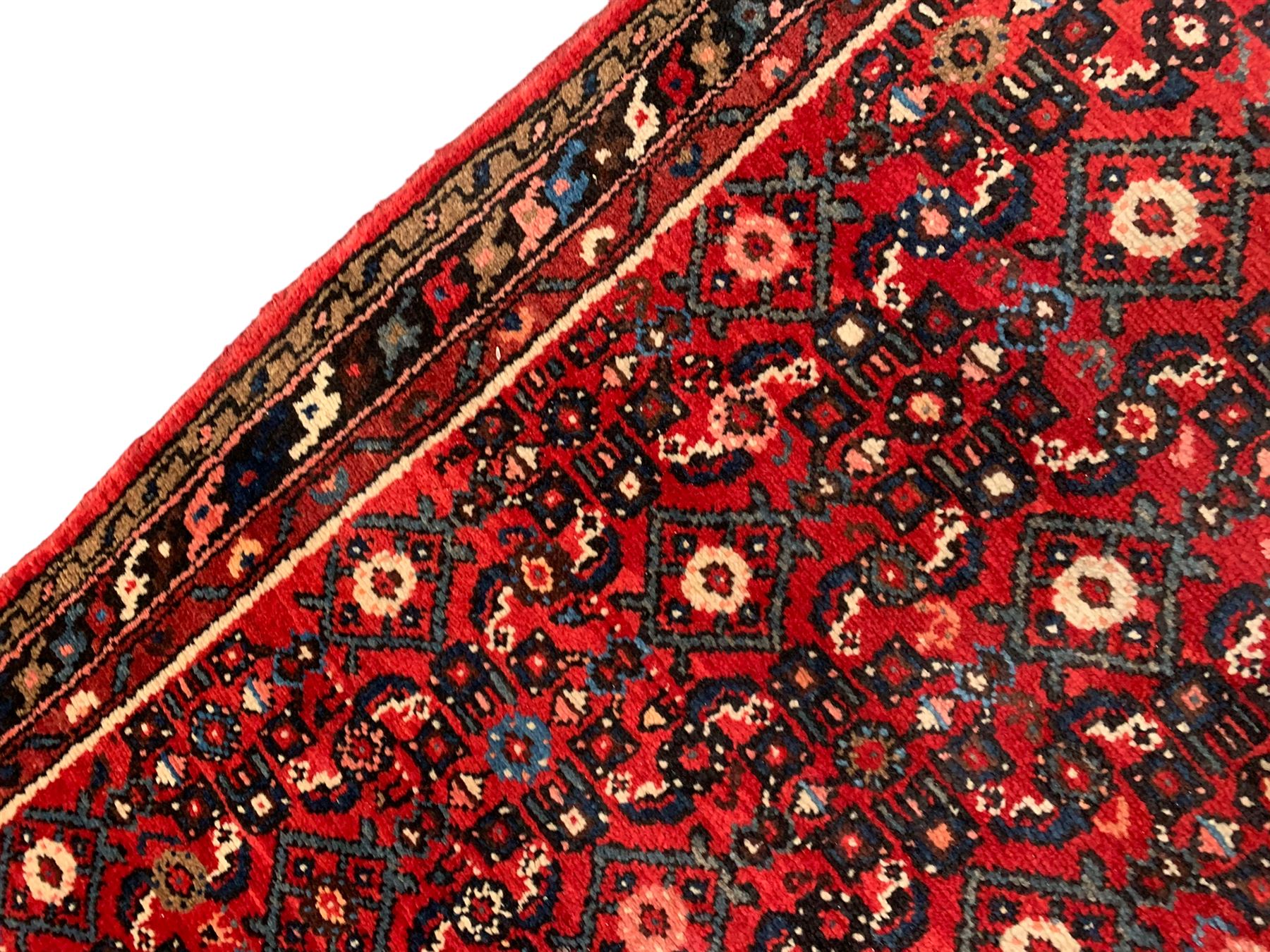 Persian crimson ground runner, the field decorated with Herati motifs,  three-band border, the main band decorated with repeating flowerheads 