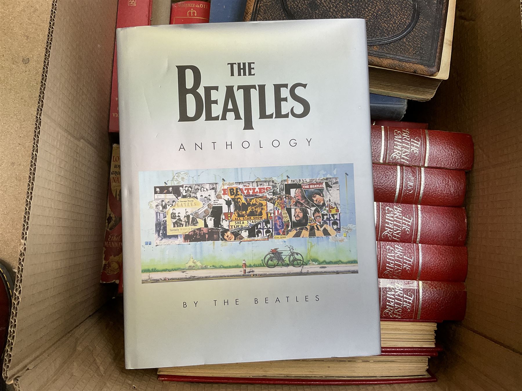 Quantity of books to include The Beatles Anthology hardback, published 2000, leather effect bound The British Empire volumes, The Times Atlas of the World, and other books to include the Bible etc
