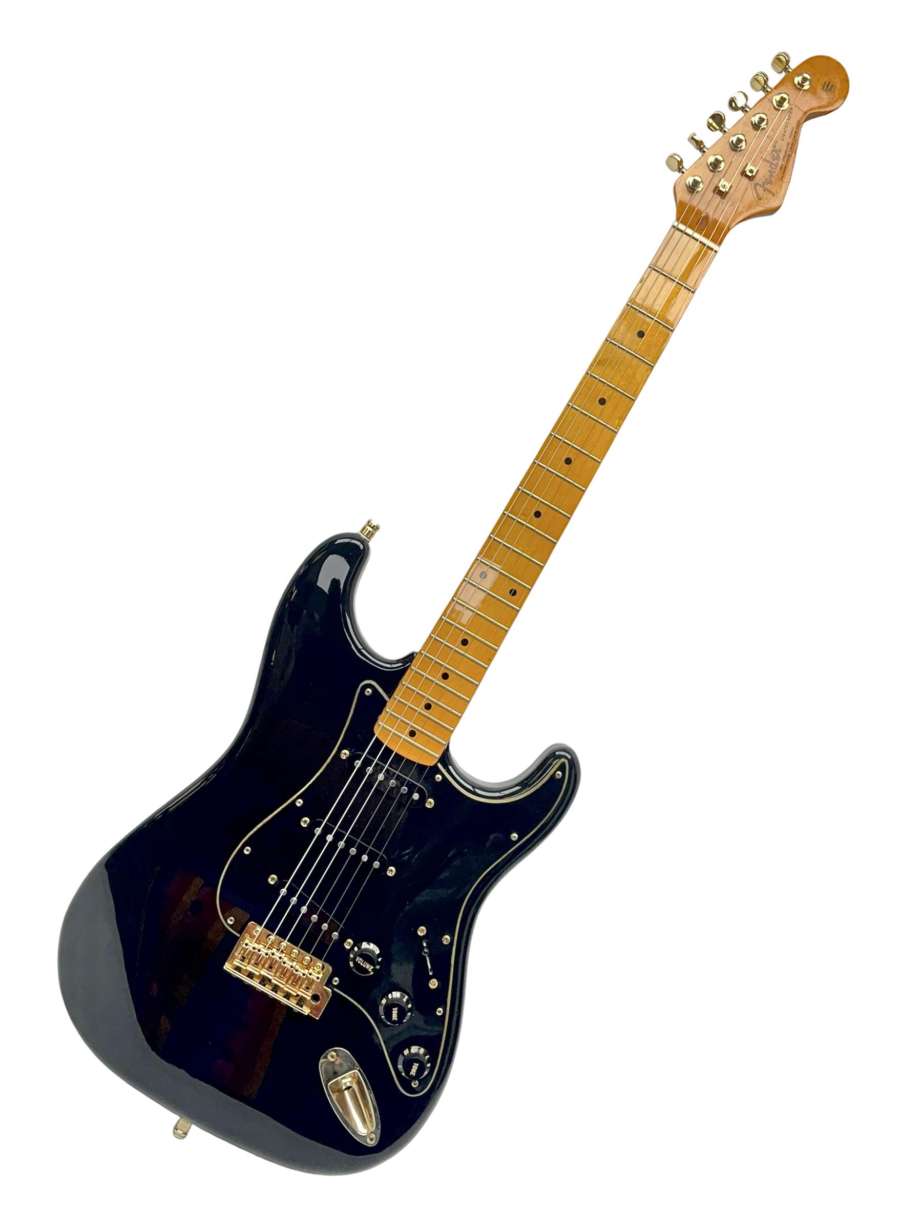 Copy of a Fender Stratocaster electric guitar in black with Wilkinson bridge, lock-in tuners, synchronised tremolo and various patent numbers; L99cm; in hard carrying case with strap and digital tuner
