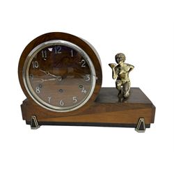 English - Art Deco three train 8-day mantle clock, in a drum case with a plated metal figure of a nude girl to the side, wooden dial with raised chrome Arabic numerals and conforming hands, chrome bezel with a convex glass, Westminster chiming movement, chiming the hours and quarters on 5 gong rods. With pendulum and key.