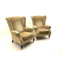 Pair of Parker Knoll armchairs, upholstered in a beige floral patterned fabric, turned supports and castors