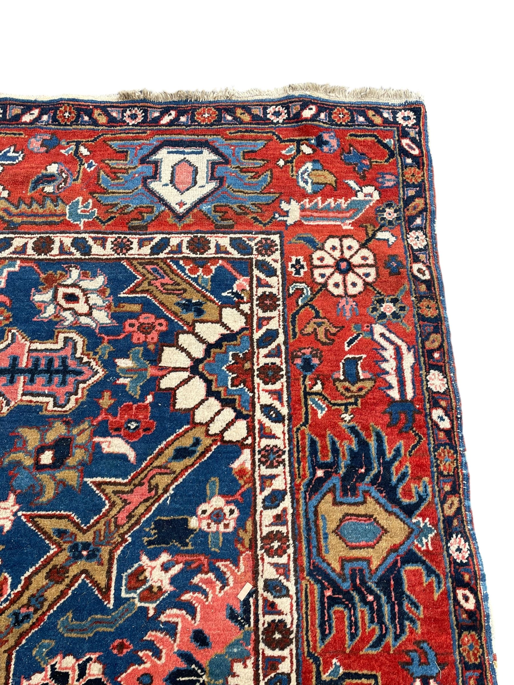 Persian blue ground carpet, the field divided up into panels by trailing bands with flower heads, each panel decorated with palmettes and stylised plant motifs, the border decorated with further palmettes, within floral pattern guard stripes 