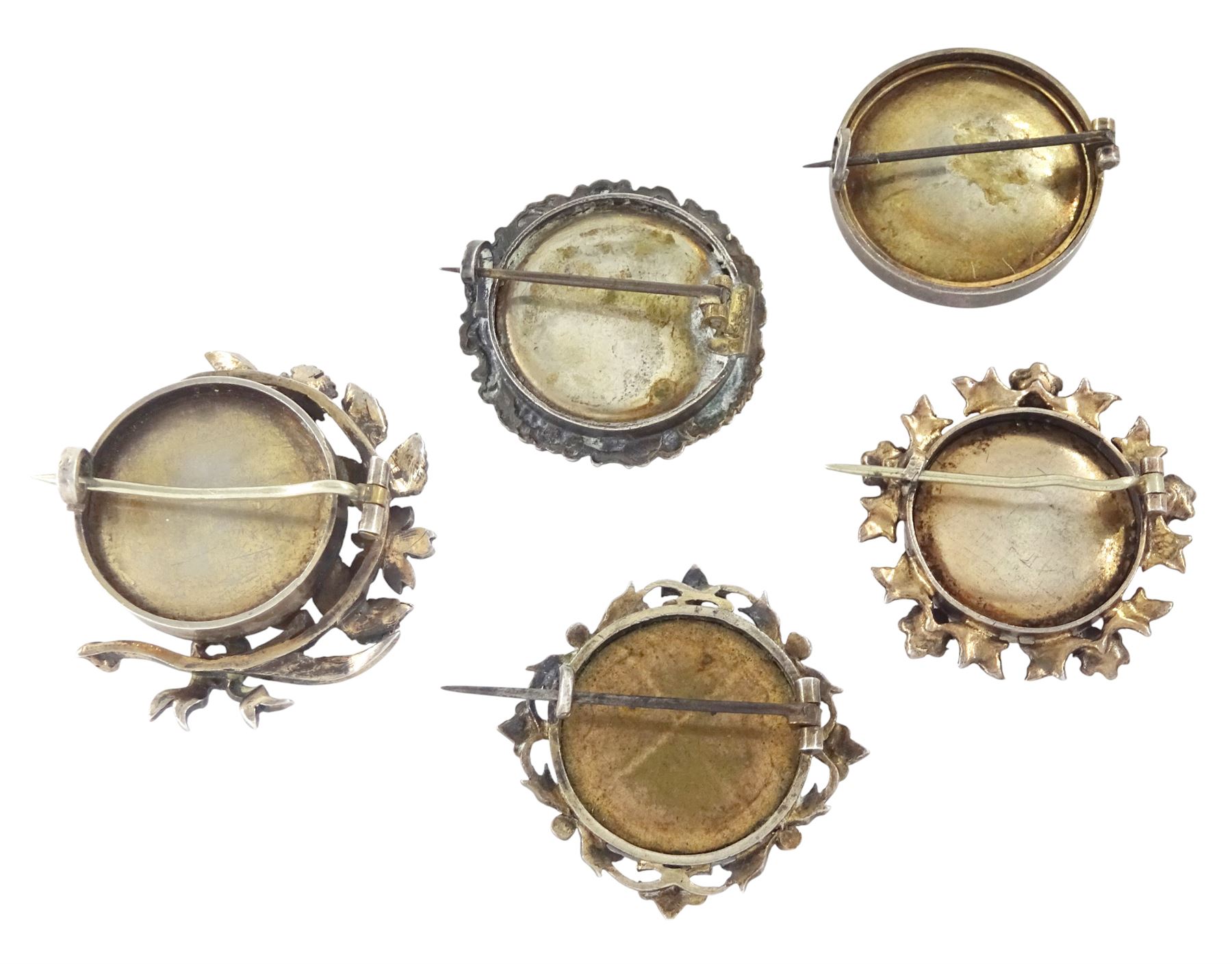 Five 19th century silver portrait brooches, two set with portraits of cherubs and three with women on ivory, three within pierced foliate surrounds. This lot has been registered for sale under Section 10 of the APHA Ivory Act
