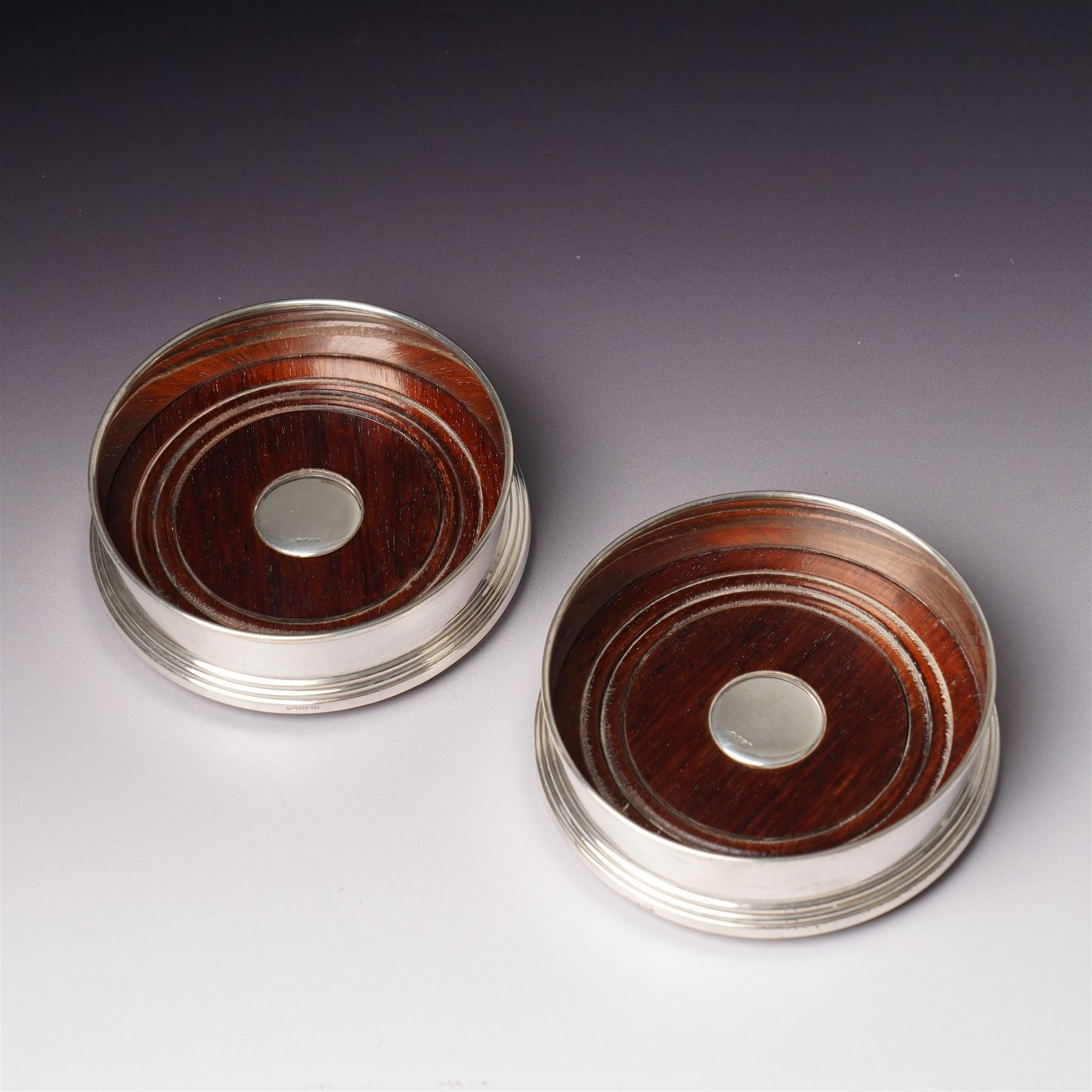 Pair of Elizabeth II silver bottle coasters with turned wooden bases D12cm, Birmingham 1994 Maker W I Broadway & Co.