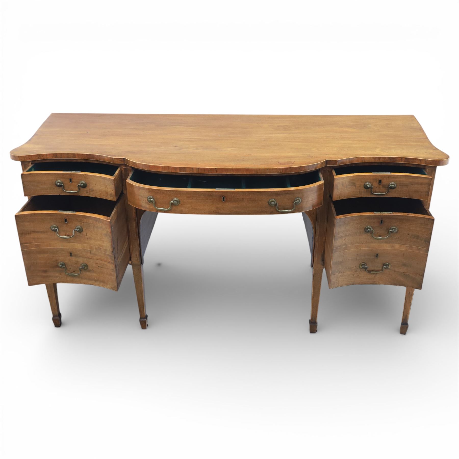 Early 20th century mahogany bow front sideboard, the shaped and moulded top above central kneehole recess with baize lined frieze drawer, flanked by twos drawers either side with the lower drawer double height, raised upon square tapering legs with spade feet