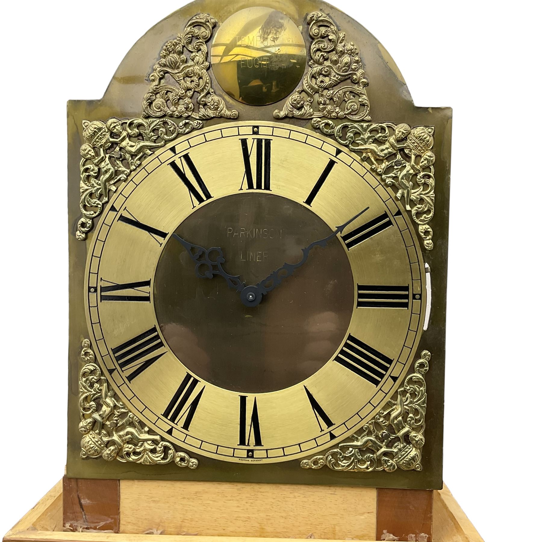 A bespoke handmade 20th century longcase clock in a slim Yew wood case with a German three train weight driven movement sounding the hours and quarters on 12 gong rods, with a brass break-arch dial, cast brass spandrels and an etched chapter ring, Roman numerals and minute track, dial engraved 'Parkinson Liner',  convex boss to the arch engraved 'Tempus Fugit', strike silent facility, With triple weights & Pendulum. 


