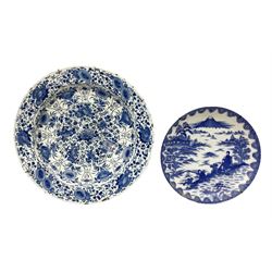 18th century Delft blue and white charger, densely decorated with painted stylised floral motifs and foliage, with painted symbols to reverse, A/F, D35cm, together with an Oriental style blue and white dish with figures in a mountainous landscape, D24cm (2)