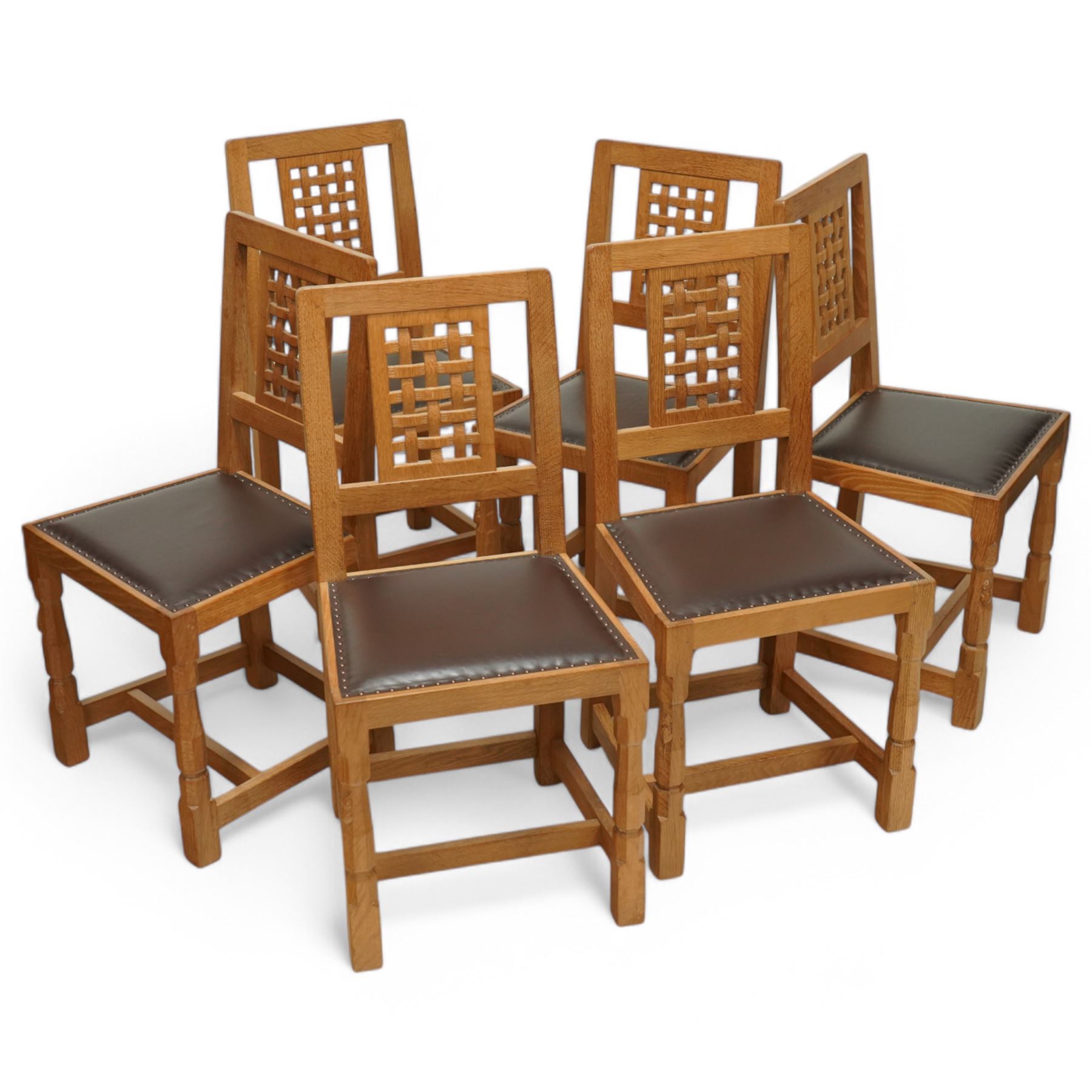 Mouseman - set of six oak dining chairs, pierced and carved lattice back over leather upholstered seat, on octagonal front supports united by stretchers, carved with mouse signature, by the workshop of Robert Thompson, Kilburn 