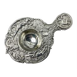 Continental white metal strainer, of shaped form embossed with classical figures, putto, musical trophies and fruiting vines, indistinctly marked, L12.5cm