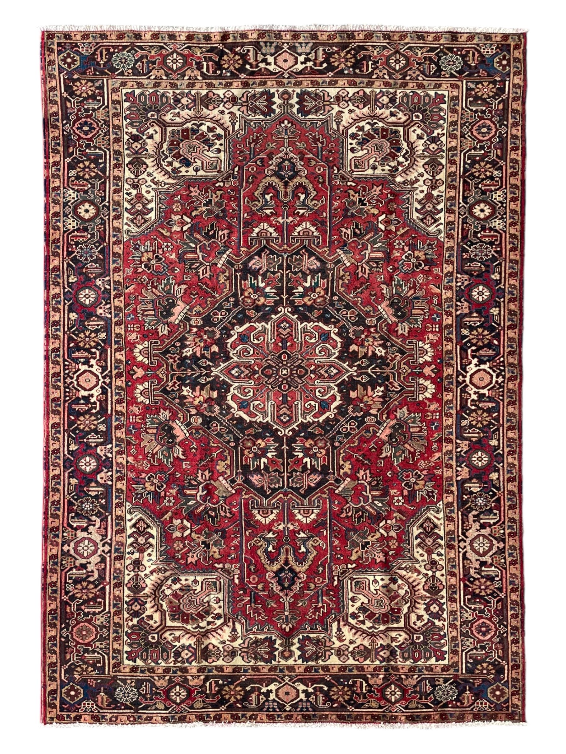 Persian Heriz red ground rug, large medallion decorated with palmettes and Ejder motifs, the border decorated with stylised plant motifs, within floral design guard stripes 