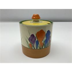 Clarice Cliff Bizarre for Newport Pottery preserve pot, of drum form decorated in the Crocus pattern, circa 1929, size 3, together with a jug painted with bands of orange, yellow, blue and green, both with black printed marks beneath, pot H9cm