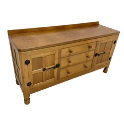 Mouseman - oak dresser, rectangular adzed top with raised back over three central drawers and two flanking cupboards, enclosed by panelled doors with wrought metal fixtures, the canted upright carved with mouse signature, on octagonal feet, by the workshop of Robert Thompson, Kilburn