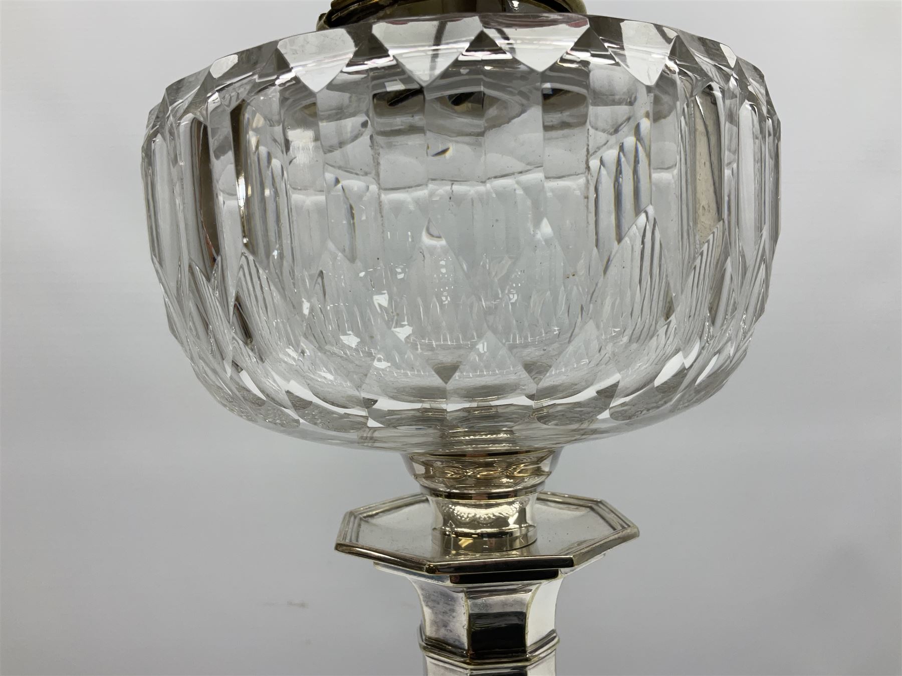 20th century Hawksworth, Eyre & Co silver plated oil lamp, the octagonal stepped base with engraved dedication, leading to an octagonal column supporting a faceted clear glass reservoir, Hinks Duplex burner, clear glass chimney, and cranberry glass shade, overall H71.5cm