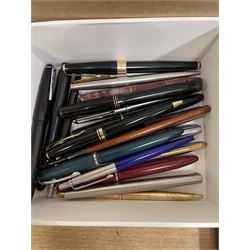 Collection of pens and accessories to include a Swan fountain pen with 14k nib, Parker 17 fountain pen, various ballpoint pens, bottles of ink, staples, Parker 51 framed advertising print, Gold Medal Pens advertising print etc 