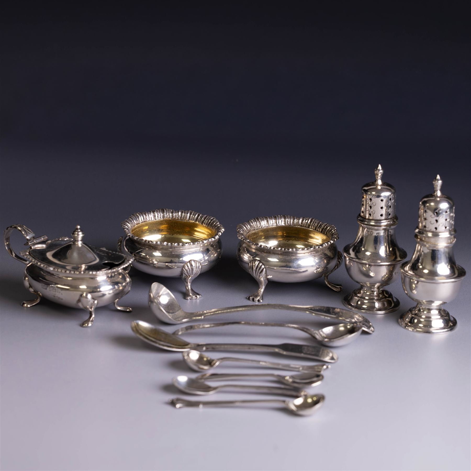 Silver cruets, including pair of open salts, mustard pot and cover, two silver pepper shakers and a collection of spoons, all hallmarked