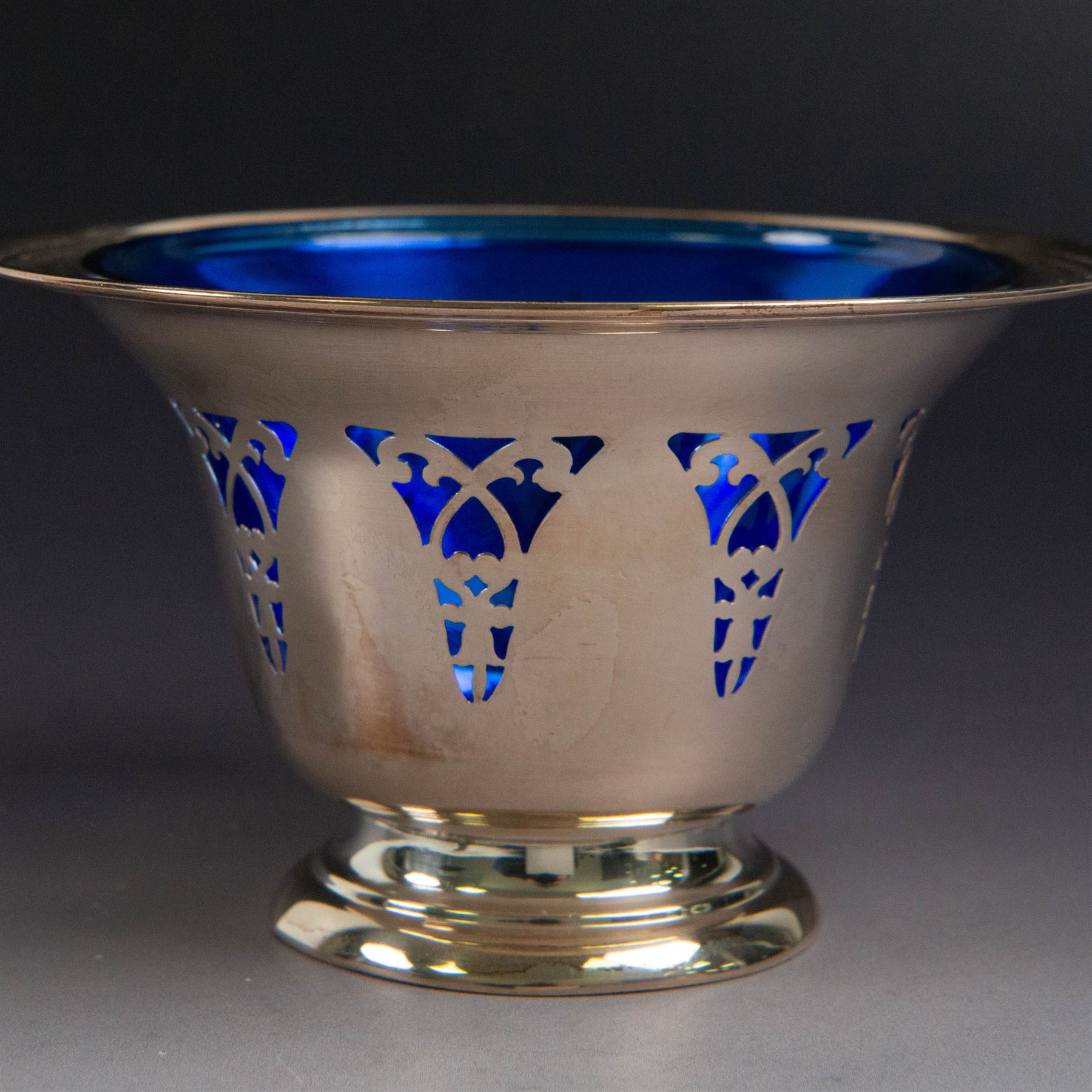 American silver sugar bowl, of circular form with fluted rim and fluted sides, upon stepped circular foot, stamped Sterling by Roden, with blue glass liner