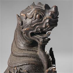 Burmese carved temple guardian figure, depicted seated with carved flame details, H52cm 