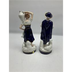 Pair of Royal Dux figures to include Shepherdess carrying a water jug with a recumbent lamb beside her, together with a male carrying a bag with a hound at his feet, both with applied pink triangle marks beneath, no. 2262 and 2261, H24cm