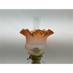Victorian brass oil lamp, the square stepped base leading to a Corinthian column supporting a part slice cut clear glass reservoir, burner, clear glass chimney and foliate etched glass shade with amber rim, overall H80cm