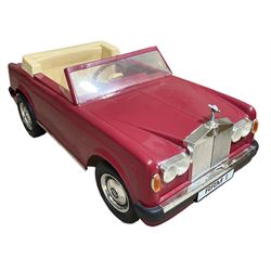 Early 1980s Rolls-Royce Corniche 'pedal' car by Sharna Tri-ang Limited, registration no.RRM1, steel chassis with treadle pedals, red moulded plastic body with flexible plastic 'Spirit of Ecstasy' car mascot on the radiator cap, opening boot lid, dashboard with decals of faux wood panelling and gauges, battery powered working electric lights, Sharna 235/70HR15 wheels with Rolls Royce hub caps, L123cm; together with two keys on RR fob, instructions manual in wallet, date stamped 17 November 1983, toy road tax disc dated 31.01.83/84 and original battery charger. 
Auctioneers Note: In 1983 Sharna Tri-ang Ltd., based at Lumb Mill in Droylsden, Manchester, took over from Tri-ang Toys at Merthyr Tydfil. They went on to launch a new range of toys based on children's TV programs, such as Knight Rider, Street Hawk, Roland Rat, The A-Team, The Get A-Long Gang and Postman Pat, as well as Rolls-Royce Corniche pedal cars, which were available in red, white or blue. 