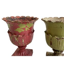 Pair of Victorian cast iron lotus garden urns, the shaped rim over lappet cast underbelly, on moulded footed base