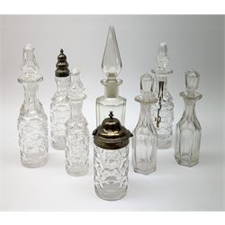 A group of Victorian glass condiment bottles, to include a set of four bottles and jar with cut decoration, one bottle with pierced silver domed top, another bottle with silver gilt spoon top, and jar with silver domed hinged cover, all hallmarked Robert Harper, London 1868. (8). 