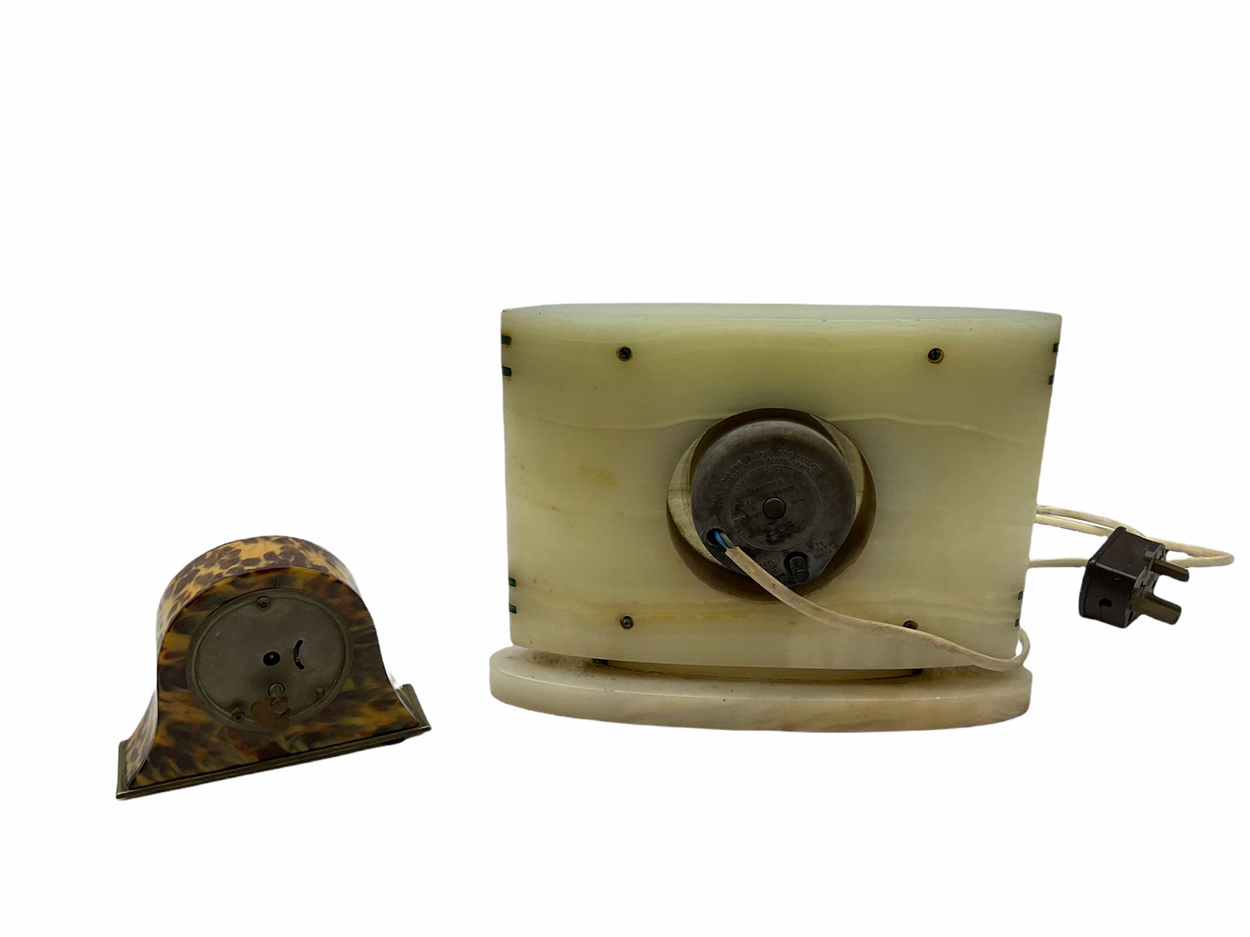 Smiths Industries SEC mains electric driven mantle clock in a rectangular Art Deco alabaster case inlaid with contrasting horizontal malachite inlay to the front, 4-1/2” square dial with brass roman numerals at 12, 3 , 6 and 9 and baton hands, with a square brass bezel and flat glass. Wiring untested, sold as a decorative item.
H 19 cm W 25 cm D 7 cm
With a small eight-day table clock in a faux tortoise shell case on a silver-plated base, 2” white dial with Arabic numerals and minute markers, steel spade hands, balance wheel movement with integral winding key. 
H 9.5 cm W 12 cm D 4 cm
